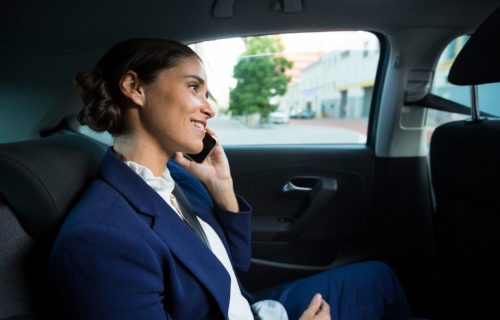 Business executive talking on mobile phone while traveling in car